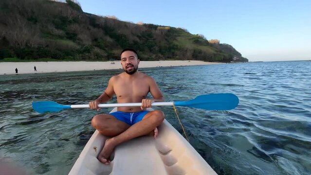 Indonesian Man Canoeing Canoe at Gunung Payung Beach, Bali, Indonesia