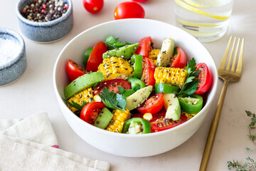 Salad with corn, avocado, tomatoes, peppers and parsley. Healthy eating. Vegetarian food.