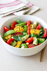 Salad with corn, avocado, tomatoes, peppers and parsley. Healthy eating. Vegetarian food.