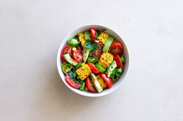 Fototapeta na wymiar Salad with corn, avocado, tomatoes, peppers and parsley. Healthy eating. Vegetarian food.