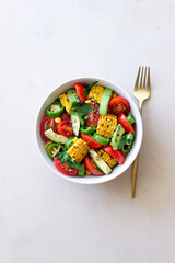 Salad with corn, avocado, tomatoes, peppers and parsley. Healthy eating. Vegetarian food.