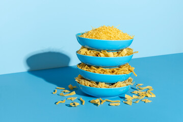 Raw pasta assortments in blue plates. Variety of uncooked pasta.