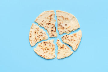 Naan bread pieces minimalist on a blue table, view from above