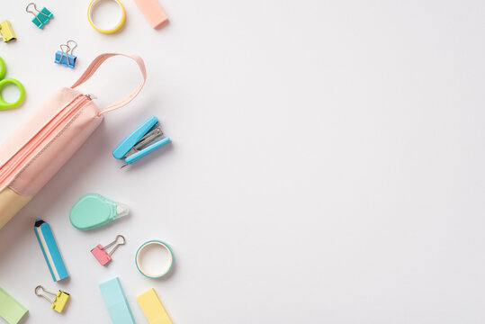 Back to school concept. Top view photo of pink pencil-case mini stapler binder clips adhesive tape round correction tape and erasers on isolated white background with copyspace