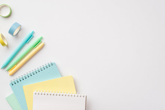 School supplies concept. Top view photo of colorful stationery planners pens and adhesive tape on isolated white background with empty space