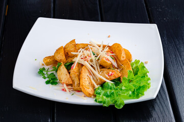 Potato wedges with cheese on plate