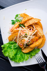 Potato wedges with cheese on plate