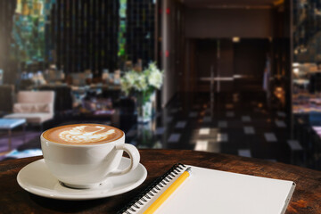  Coffee aroma in cup breakfast morning drink on wooden table in cafe shop with note pad and newspaper background.