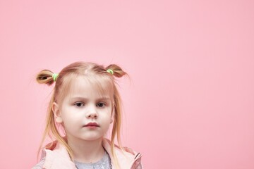 Fototapeta premium a child in a jacket on a pink background.