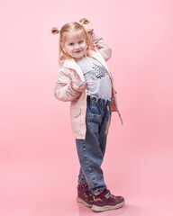 a child in a jacket on a pink background.