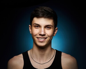 Obraz premium Portrait of a beautiful boy on a black background. Portrait of a young caucasian man. Attractive teenager..