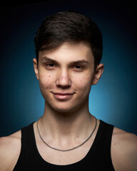 Fototapeta premium Portrait of a beautiful boy on a black background. Portrait of a young caucasian man. Attractive teenager..