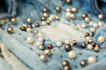 Jeans background clothing. Denim fabric closeup. Textures of clothing made of fabric with fashionable embroidery of pearl beads. Copy space for text. Fashionable style.