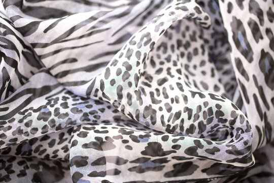 Satin fabric close up background and texture with place for text. Gray leopard print chiffon or silk material.