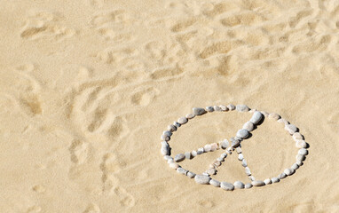 Peace sign made of pebbles on sandy beach. Peace symbol, no war, stop war, pacifism concept.