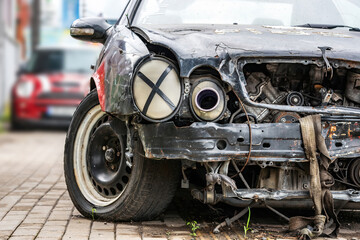 Fototapeta premium Auto accident. Crashed car in the street. Damaged civilian sport car after collision