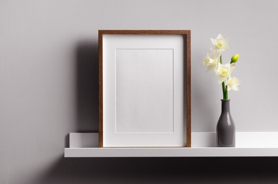 Vertical wooden frame mockup on shelf with flowers