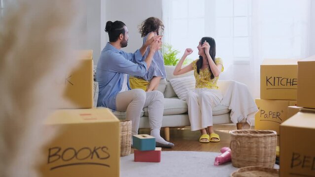 happiness joyful family moment dad mom and daughter playing together sit on the floor while preparing to unpack stuff home moving in living room at new home,daughter bring balloon to show to parents