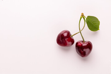 Cherry berries on a pastel background top view.  Background with a cherry on a sprig, flat lay