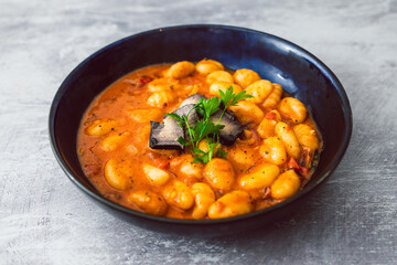healthy plant-based food, vegan potato gnocchi with bell pepper sauce and ashed cashew cheese