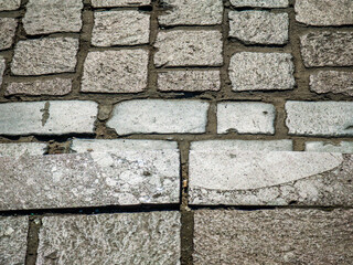Background texture of tiled stone road. Grey rough bricks.