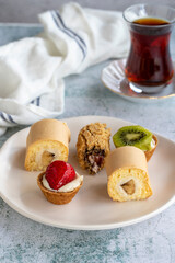 Delicious snacks. Roll cake, chocolate chip cake and fruit tart on a stone background. close up