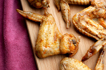 Baked chicken wings on a cutting board. Meat in the form of chicken wings. Appetizing chicken wings close-up.