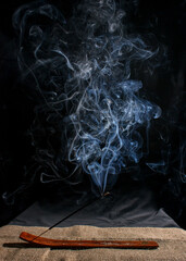 indian incense stick with smoke on black background