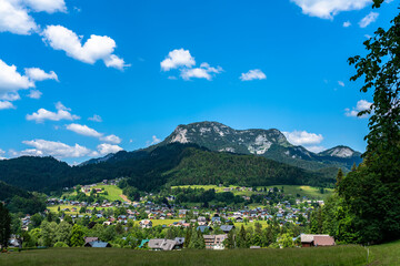 Beautiful idyllic panorama view of village near Altaussee with the peak Sarstein in background on a sunny summer day with blue sky cloud, Salzkammergut-Ausseerland region, Styria, Austria - 517337353