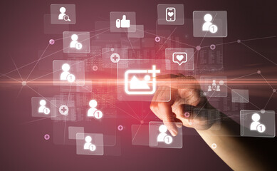 Hand pressing social media multimedia application screen with media icons on futuristic concept