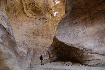 Dana Biosphere Reserve in Jordan. Amazing rocks in Wadi Ghuweir Canyon. Silhouette of hiking person on trail.	