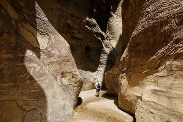 Dana Biosphere Reserve in Jordan. Amazing rocks in Wadi Ghuweir Canyon. Silhouette of hiking person on trail.	 - obrazy, fototapety, plakaty