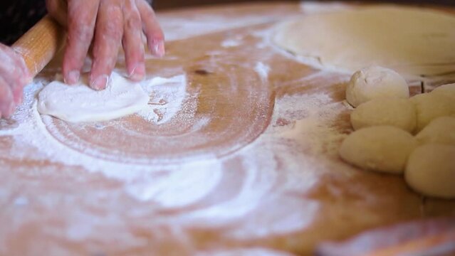 Women's hands in the process of cooking kutaba or chebureks, minced meat and onions in the dough. Azerbaijani, Tatar, Caucasian, Greek cuisine.