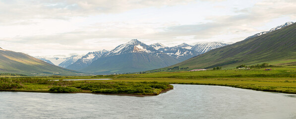 Icelandic panorama of mountains and river with snow on peak in the region of Akureyri