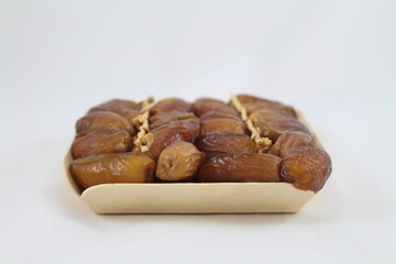 Cardboard tray of date fruits on grey background