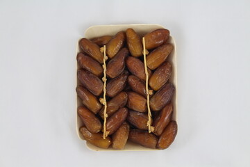 Cardboard tray of date fruits on grey background