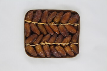 Cardboard tray of date fruits on grey background