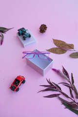 Fashion and beauty concept lying flat with square glasses, women's accessories on pink background.