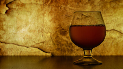 a glass with a wine on the stone wall  background