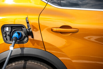 Close up for the socket of the electric car during charging. Modern electro mobility in everyday...