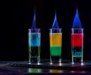 Cocktails Party Shots and Shooters on bar counter in a restaurant, pub. Miniature mixed drinks. Alcoholic cooler beverage at nightclub on dark background
