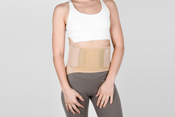 Orthopedic lumbar corset on the human body. Back brace, waist support belt for back. Posture Corrector For Back Clavicle Spine. Post-operative Hernia Pregnant and Postnatal Lumbar brace after surgery. - obrazy, fototapety, plakaty