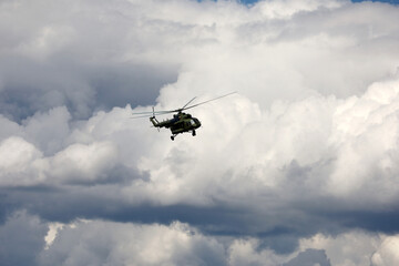 Fototapeta na wymiar Russian military helicopter Mi-8 (NATO codification: Hip) in flight on white clouds background