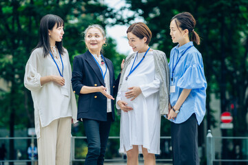 妊娠中の女性と話す、さまざまな年代の女性