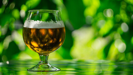 glass with beer on green blurred background