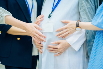 妊娠中の女性と話す、さまざまな年代の女性
