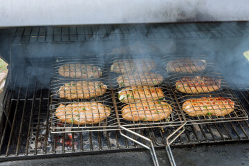 At a hot BBQ grill, burgers beef roast with a mix of American barbecue food