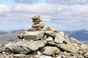 stone mound at the peak of a Scottish mountain called Beinn a Chorin. Beautiful green Scottish mountainous scenery in summer 