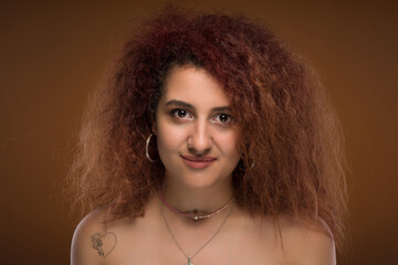 Fototapeta premium A young beautiful girl with brown eyes and long curly hair.