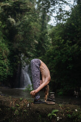 Yoga practice and meditation in nature. Man practicing near river